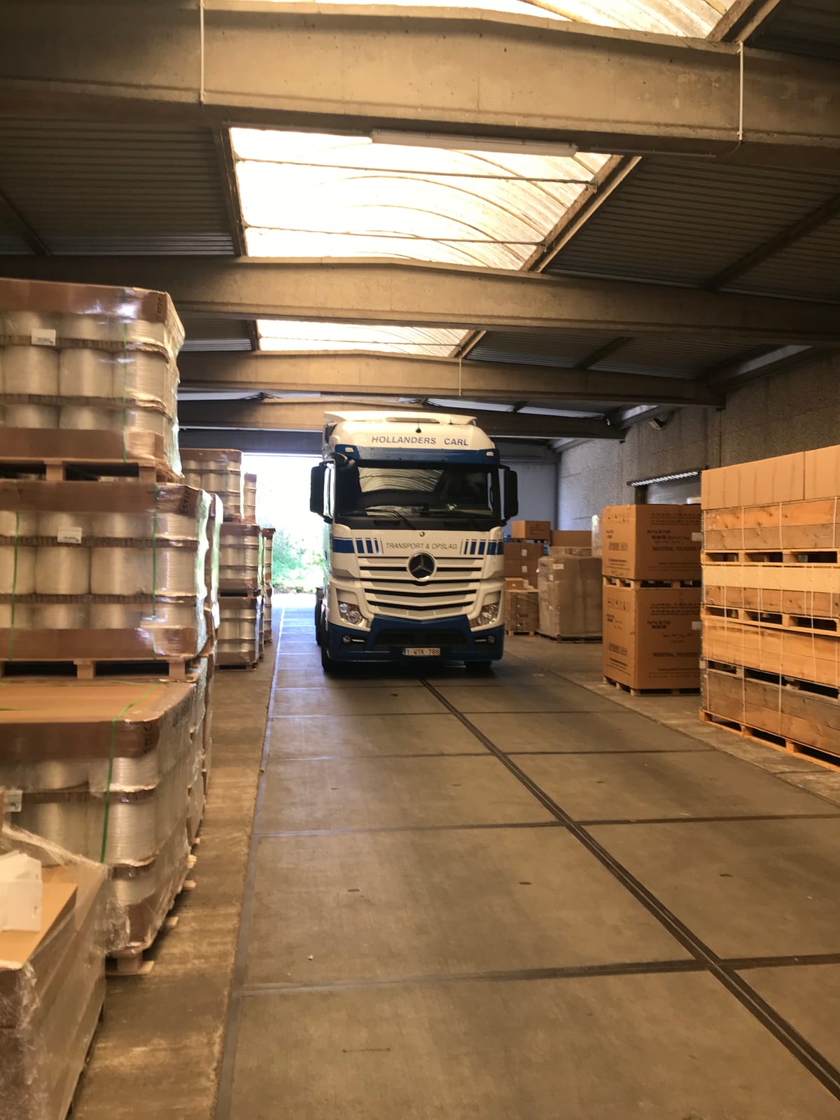 Hollanders Carl vrachtwagen in de loods tussen gepalletiseerde goederen