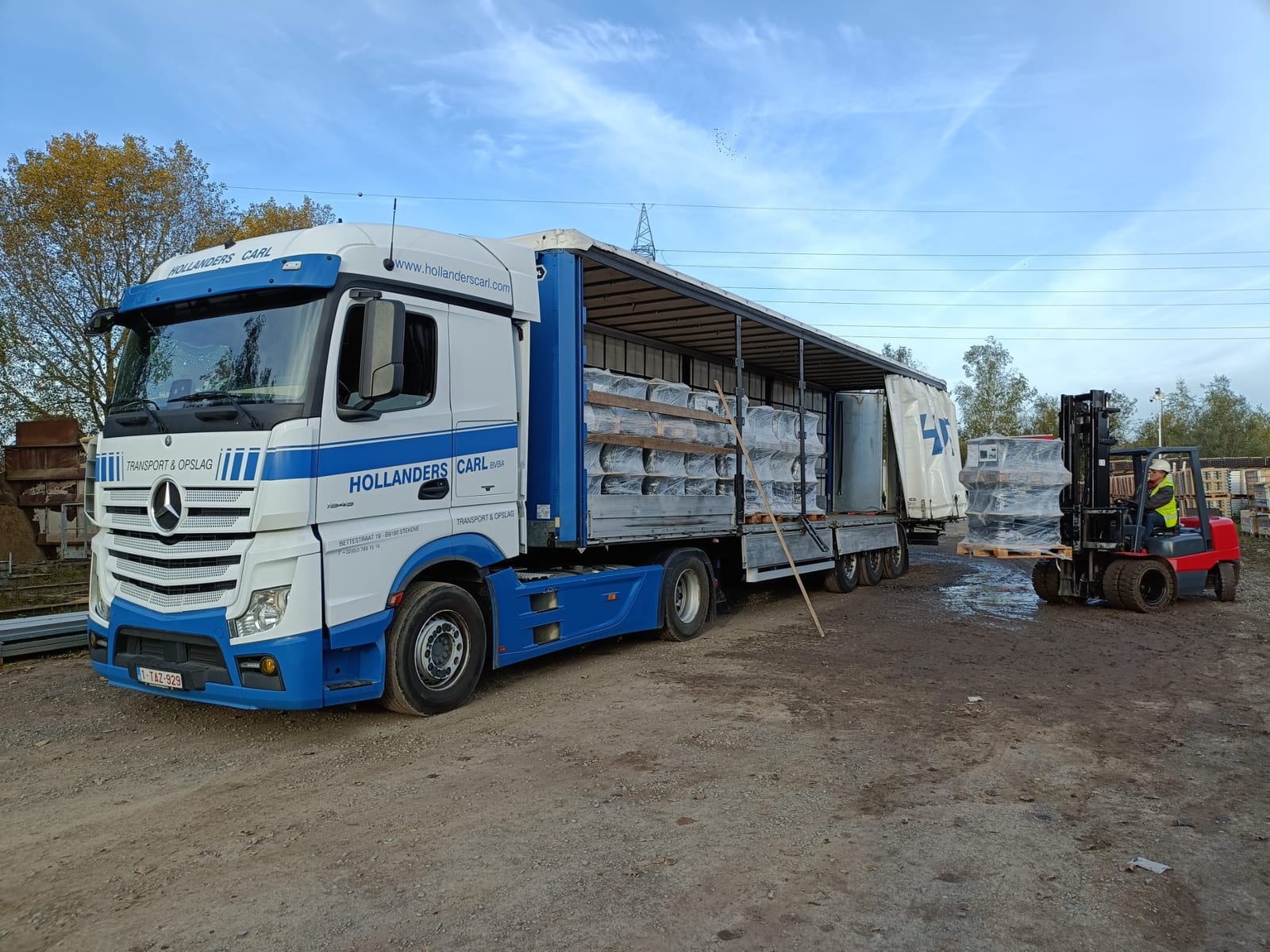 Hollanders Carl schuifzeiltrailer wordt met een heftruck beladen op het terrein