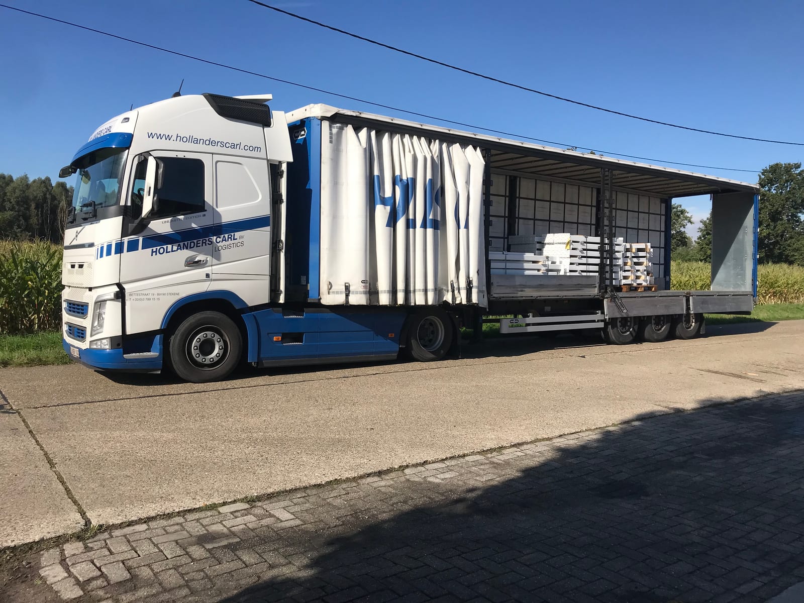 Hollanders Carl vrachtwagen met schuifzeiltrailer geladen met bouwmaterialen op pallets